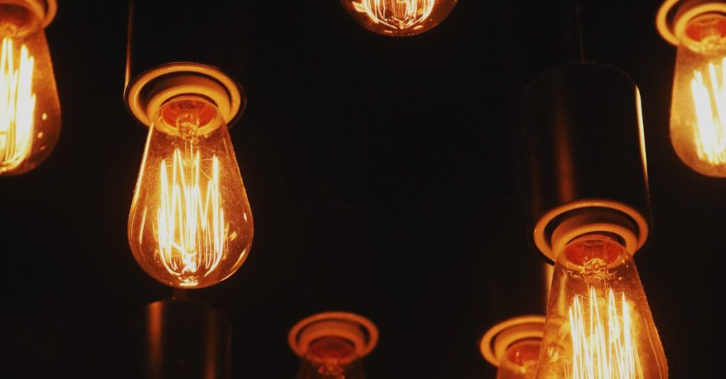 Multiple vintage Edison lightbulbs glowing warmly against a dark backdrop.